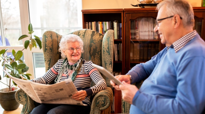 two residents smiling while reading