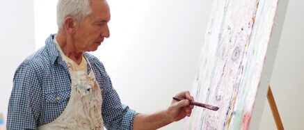 Older man painting with canvas