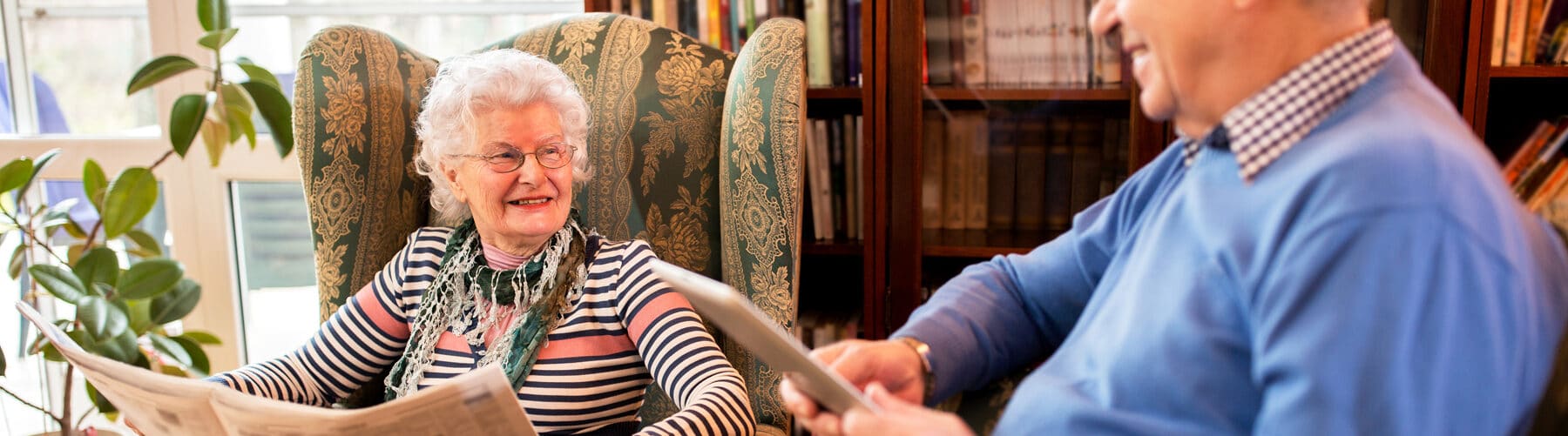two residents smiling while reading