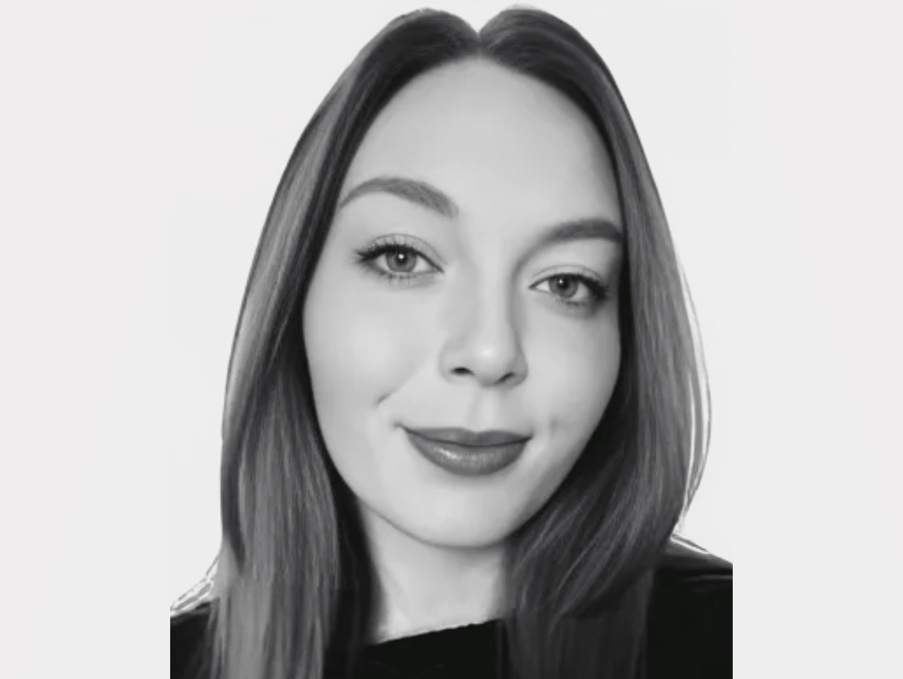 Black and white headshot of Chloe Metcalfe, Teams Administrator, with long straight hair, wearing a dark top, and smiling subtly.