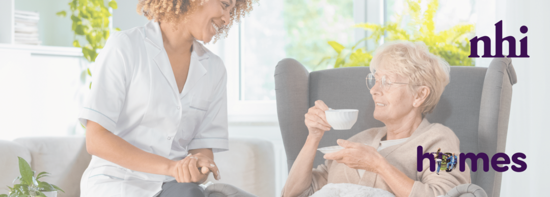 A smiling healthcare professional in a white uniform engages in conversation with an elderly woman enjoying a cup of tea while sitting in a comfortable chair. The setting is bright and welcoming, with green plants in the background. The Nursing Homes Ireland (NHI) and HOMES logos are displayed on the image, representing care and support for nursing home residents.