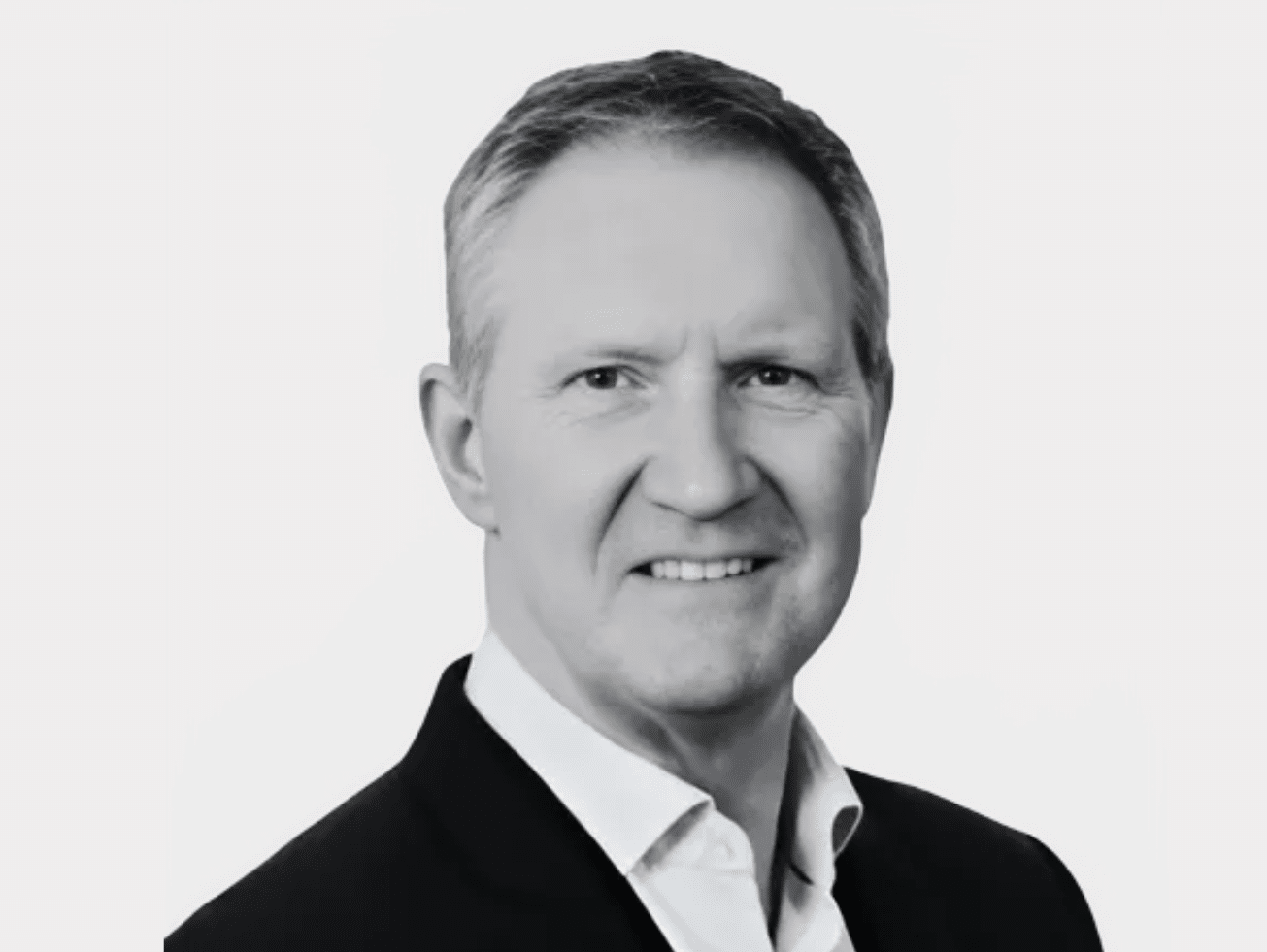 Black and white headshot of Liam Harvey, Member Business Support Specialist, wearing a dark suit with a white shirt and smiling.